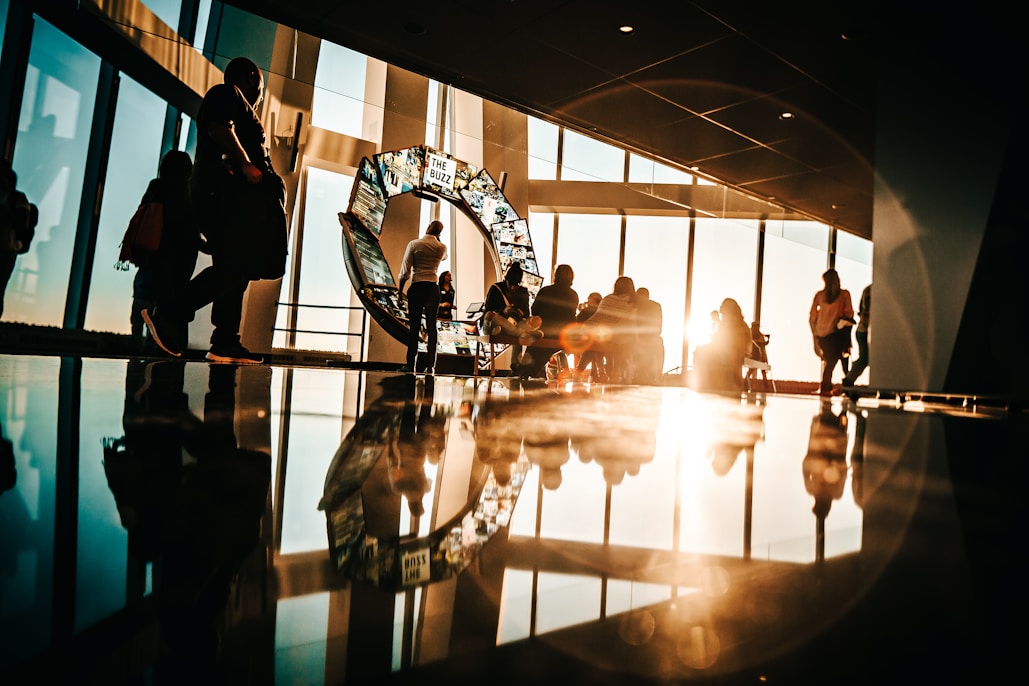 People in a large room with a circular display and windows.
